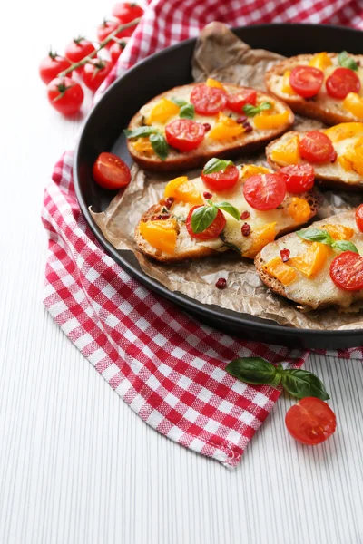 Bruschetta saporita con pomodori, in tavola — Foto Stock