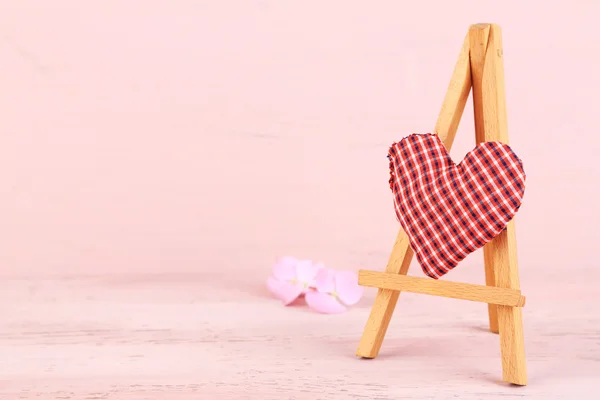 Bellissimo cuore piccolo cavalletto decorativo su sfondo rosa — Foto Stock