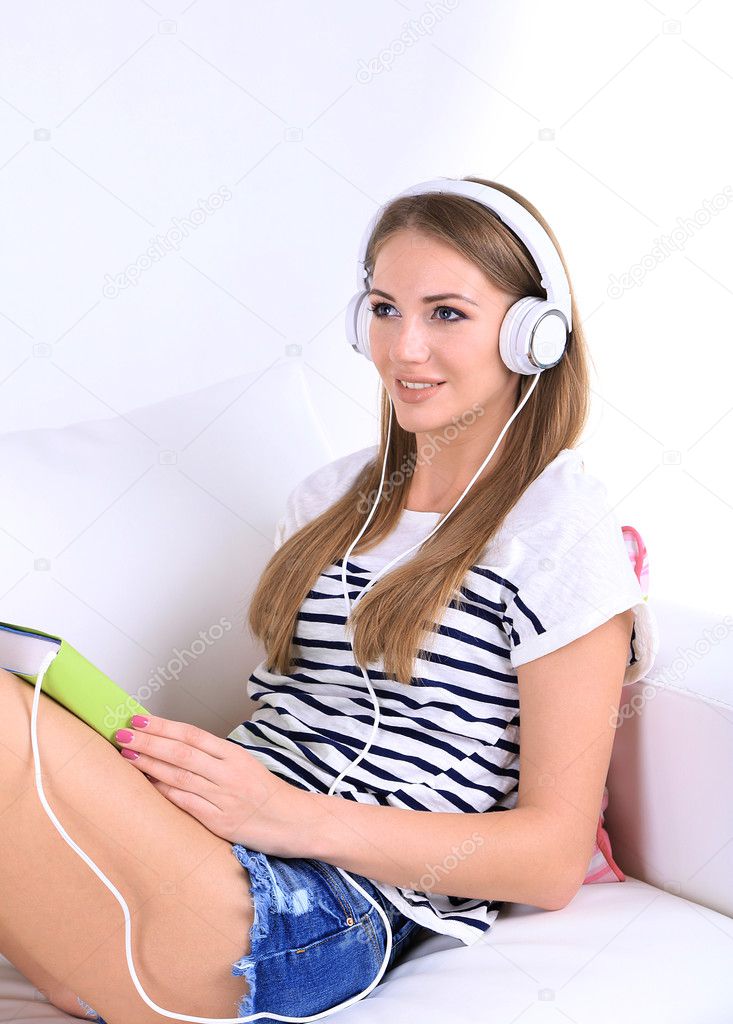 Conceptual image of  audio book. Beautiful girl with book and headphones.