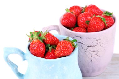 Olgun tatlı çilek rengi kupalar üzerinde beyaz izole kesme tahtası üzerinde yapılan