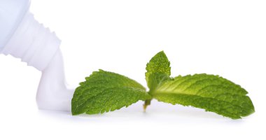 sıkılmış diş macunu tüpünden, üzerinde beyaz izole yaprakları, yakın çekim, nane