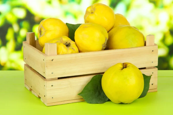 Zoete kweeperen in houten doos op tafel op lichte achtergrond — Stockfoto