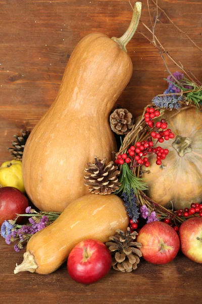Podzimní složení jablka, dýně, květin a suché větve na dřevěný stůl na dřevěné pozadí — Stock fotografie