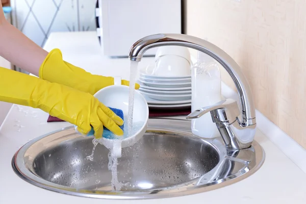 Close up hands of woman washing dishes in kitchen — Stock Photo, Image