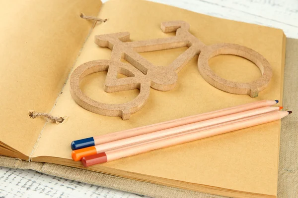 Decorative bicycle with pencils on book close up — Stock Photo, Image