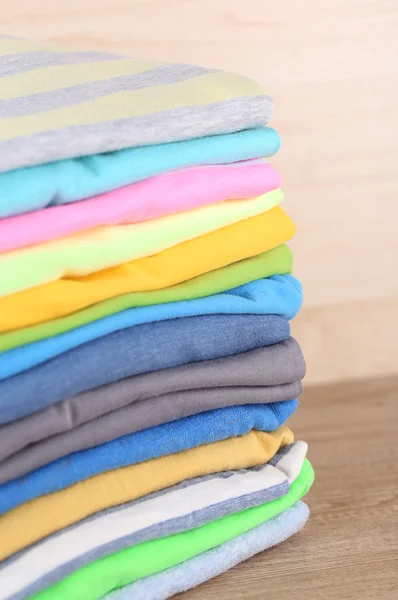 Pilha de roupas coloridas, no fundo claro — Fotografia de Stock