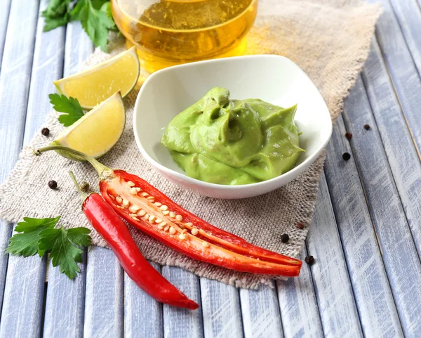 Fresh guacamole in bowl on wooden table — Stock Photo, Image