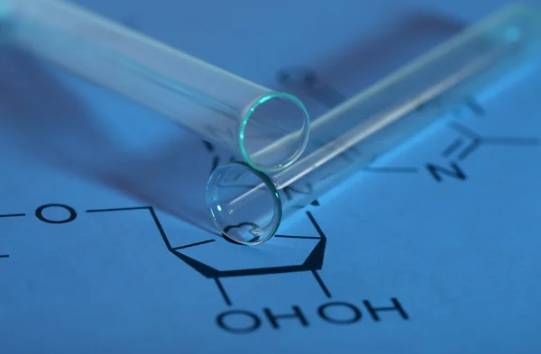 Test tubes and reaction formula, close-up — Stock Photo, Image