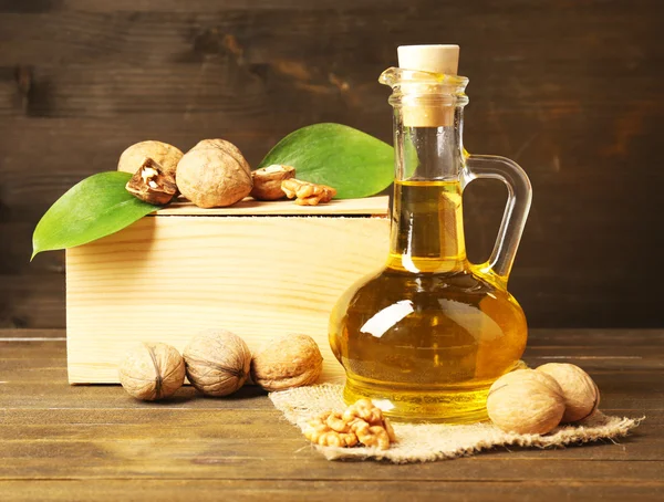 Walnut oil and nuts on wooden table — Stock Photo, Image