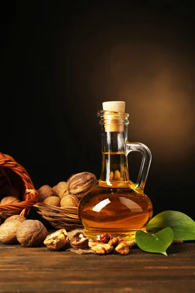 Aceite de nuez y nueces sobre mesa de madera — Foto de Stock