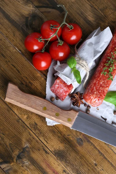 Saporito salame salsiccia e spezie su sfondo di legno — Foto Stock