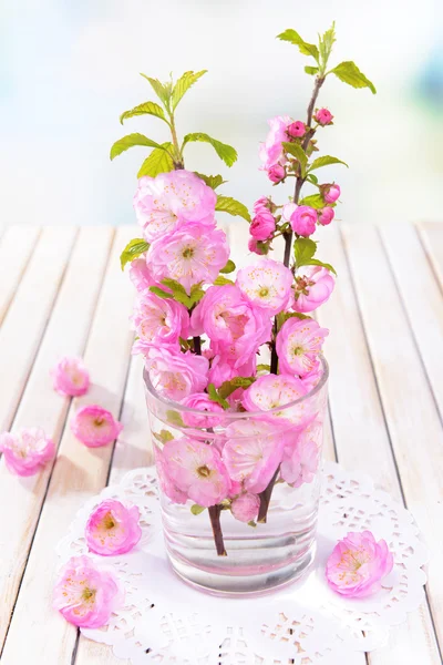 Mooie fruit blossom in glas op tafel op lichte achtergrond — Stockfoto