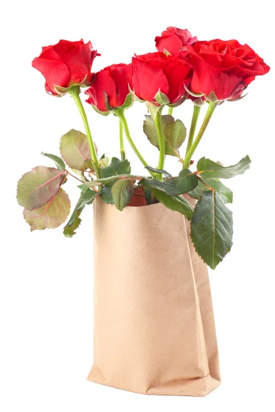 Vackra rosor i papperspåse isolerad på vit — Stockfoto