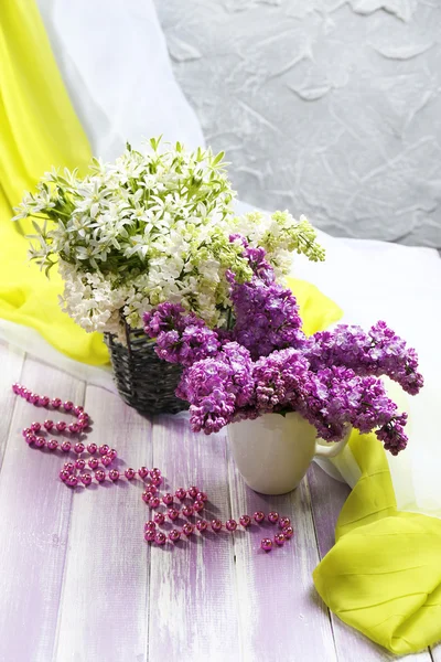 Beautiful lilac flowers on wooden table — Stock Photo, Image