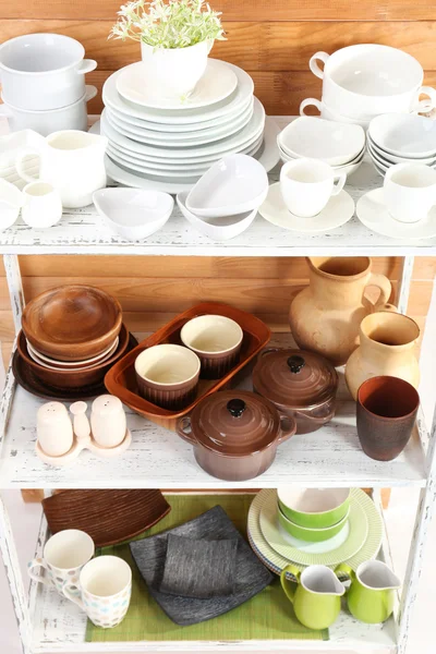 Different tableware on shelf, on wooden background — Stock Photo, Image