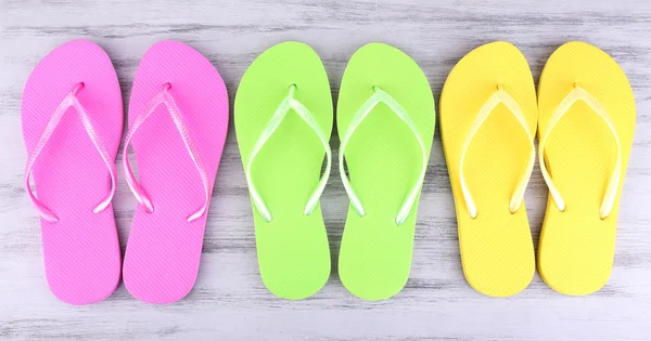 Chanclas brillantes sobre fondo de madera de color — Foto de Stock