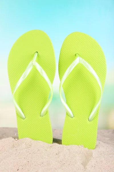 Bright flip-flops on sand, on nature background — Stock Photo, Image