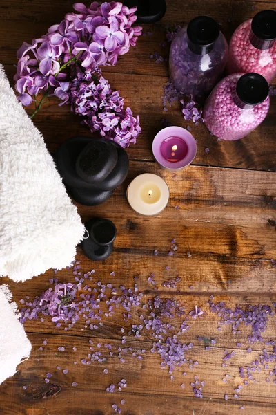 Composición con tratamiento spa, toallas y flores lila, sobre fondo de madera —  Fotos de Stock
