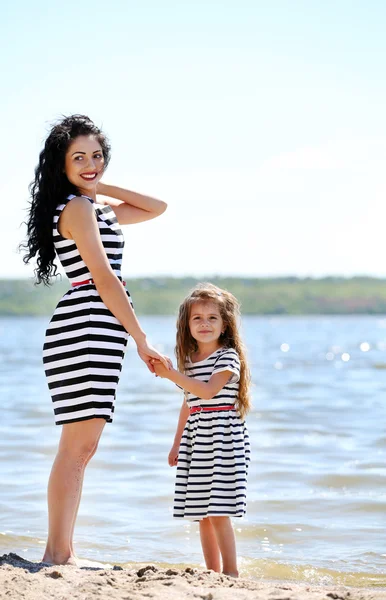 Happy mom and daughter on the beach — Stock Photo, Image