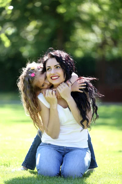 Mãe feliz e filha no parque verde — Fotografia de Stock