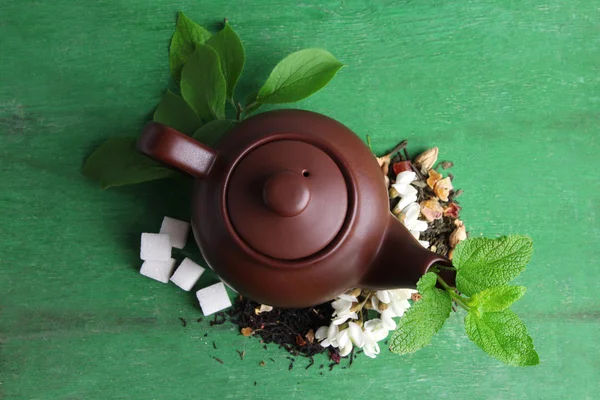 Pflanzlicher natürlicher floraler Tee-Aufguss mit trockenen Blumen und Kräuterzutaten, auf farbigem Holzhintergrund — Stockfoto