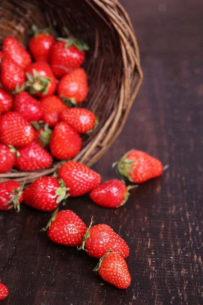 Ripe sweet strawberries in wicker basket on wooden background — Stock Photo, Image