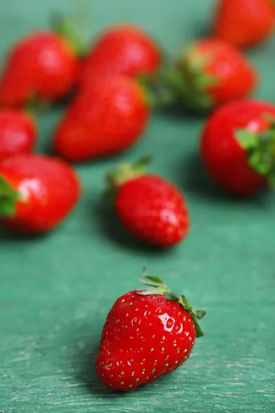 Fraises douces mûres sur fond de bois couleur — Photo