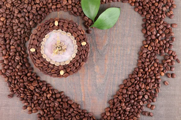 Schöne Uhr aus Kaffeebohnen, auf Holzgrund — Stockfoto