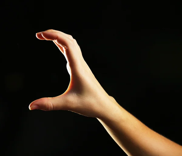 Mänsklig hand på svart bakgrund — Stockfoto