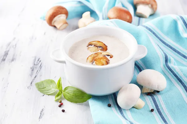 Mushroom soup in white pot, on napkin, on wooden background — Stock Image Mushroom soup in white pot, on napkin, on wooden background Stock Photo