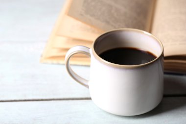 ahşap zemin üzerinde eski kitap ve sıcak kahve Kupası