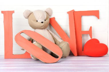 Dekoratif harf kelime aşk oyuncak ayı ile ahşap arka plan üzerinde şekillendirme