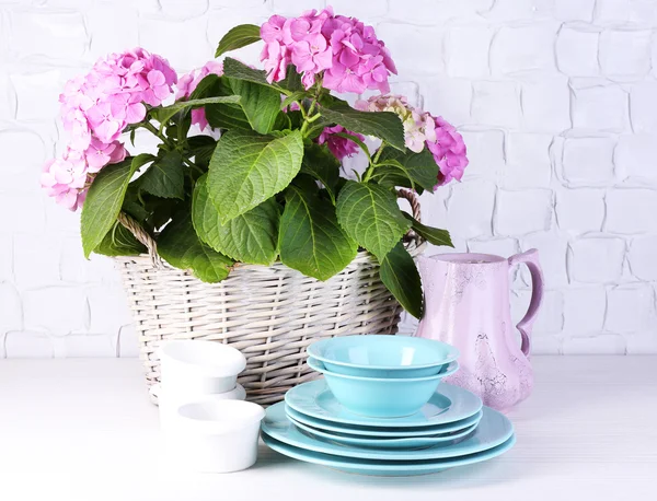 Hortensias et ustensiles fleuris sur table sur fond de mur gris — Photo