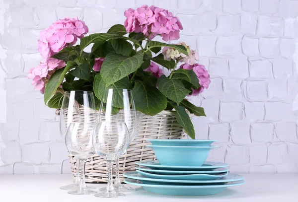 Bloeiende hortensia en gebruiksvoorwerpen op tafel op grijs muur achtergrond — Stockfoto