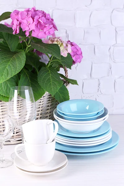 Blooming hydrangea and utensils on table on grey wall background — Stock Photo, Image