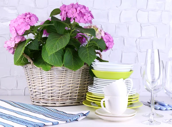 Blooming hydrangea and utensils on table on grey wall background — Stock Photo, Image