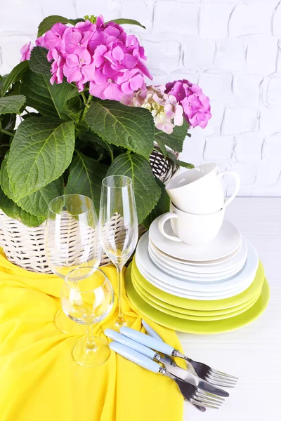 Hortensias et ustensiles fleuris sur table sur fond de mur gris — Photo