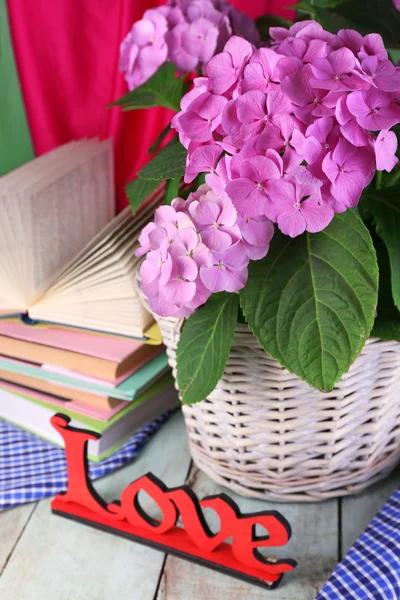 Hydrangea in basket with books close-up — Stock Photo, Image