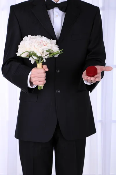 Hombre celebración de ramo de boda y anillo sobre fondo claro —  Fotos de Stock