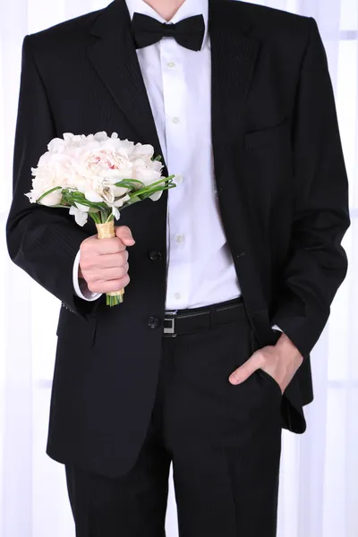 Man holding wedding bouquet on light background — Stock Photo, Image