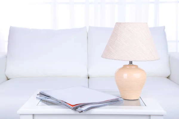 Журнали та лампа на кавовому столі в кімнаті — стокове фото