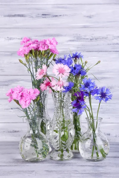 Belles fleurs d'été dans des vases sur fond de bois gris — Photo