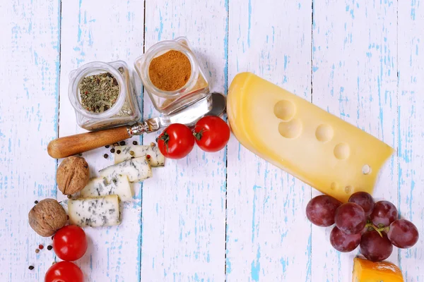 Diferentes tipos de queso con verduras y especias en primer plano de la mesa — Foto de Stock