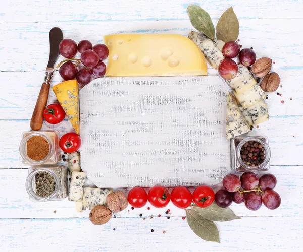 Различные виды сыра с пустой доской на столе крупным планом — стоковое фото