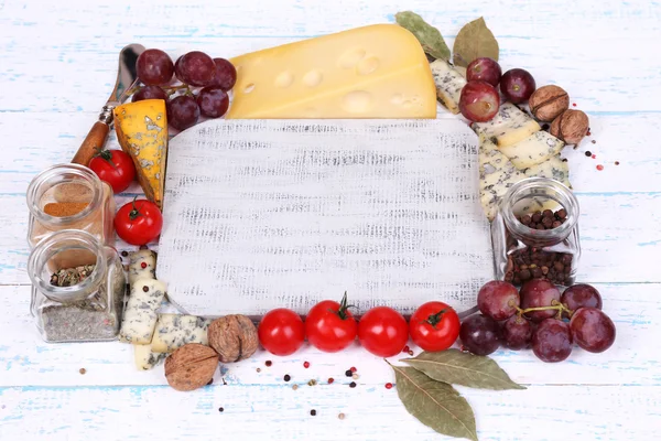 Different types of cheese with empty board on table close-up — Stock Photo, Image