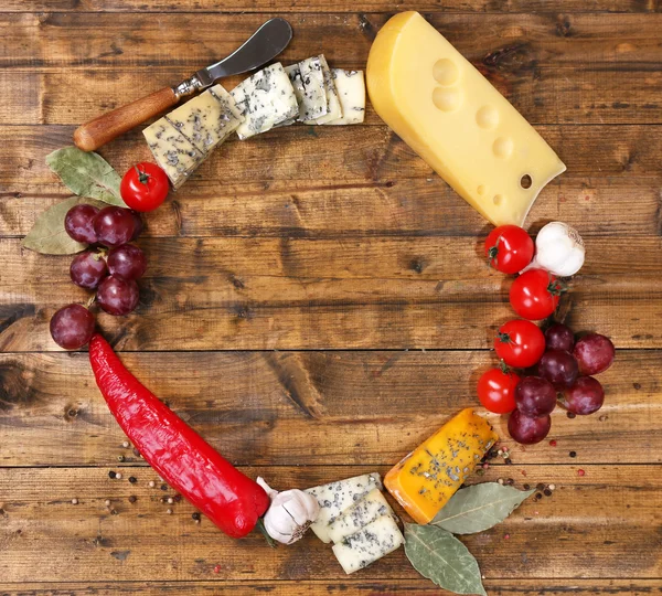 Diferentes tipos de queso con verduras y especias en primer plano de la mesa — Foto de Stock