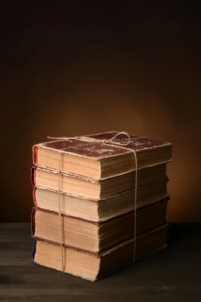 Oude boeken op tafel op bruine achtergrond — Stockfoto