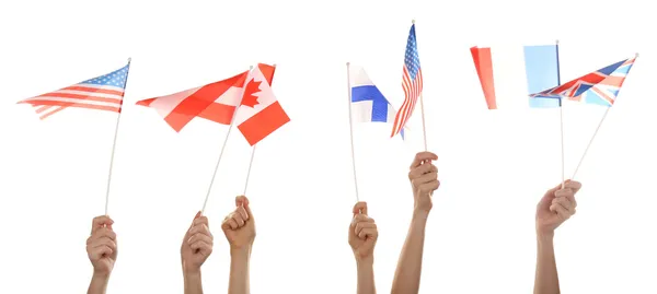 Hands holding different flags, isolated on white — Stock Photo, Image