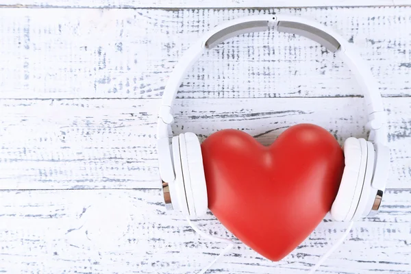 Headphones and heart on wooden background — Stock Photo, Image