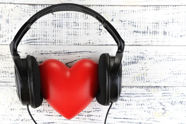 Headphones and heart on wooden background — Stock Photo, Image